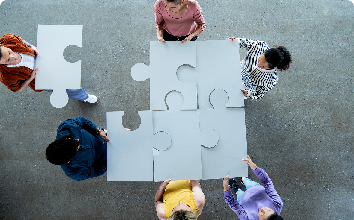 People assembling large puzzle pieces together.
