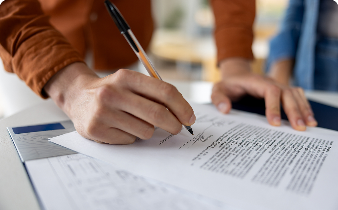 Signing a document with a pen.