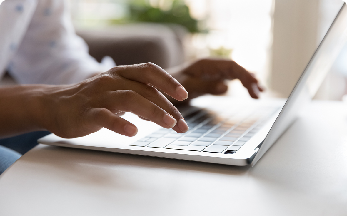 Hands typing on a laptop keyboard.